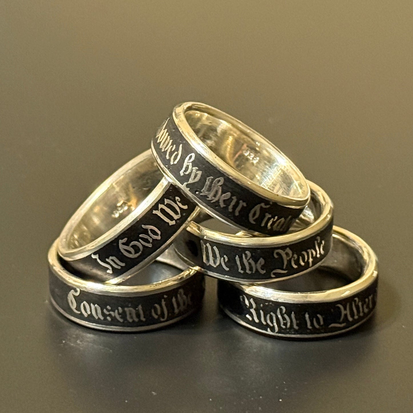 Collection of handmade embedded text silver bands with USA Patriot Theme