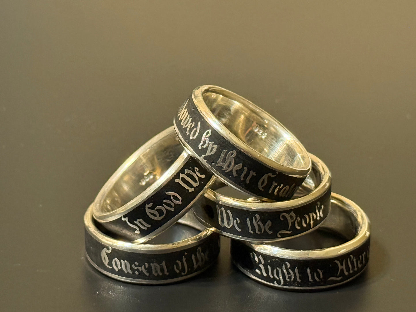 Collection of handmade embedded text silver bands with USA Patriot Theme
