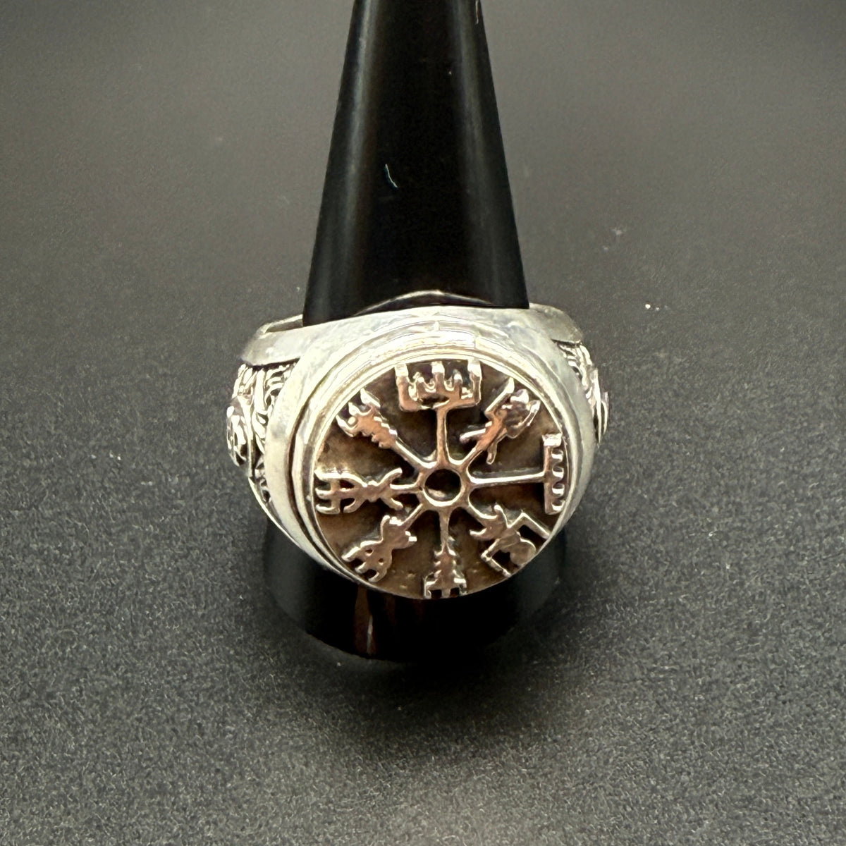 A sterling silver Viking-style ring with a raised compass motif and textured details