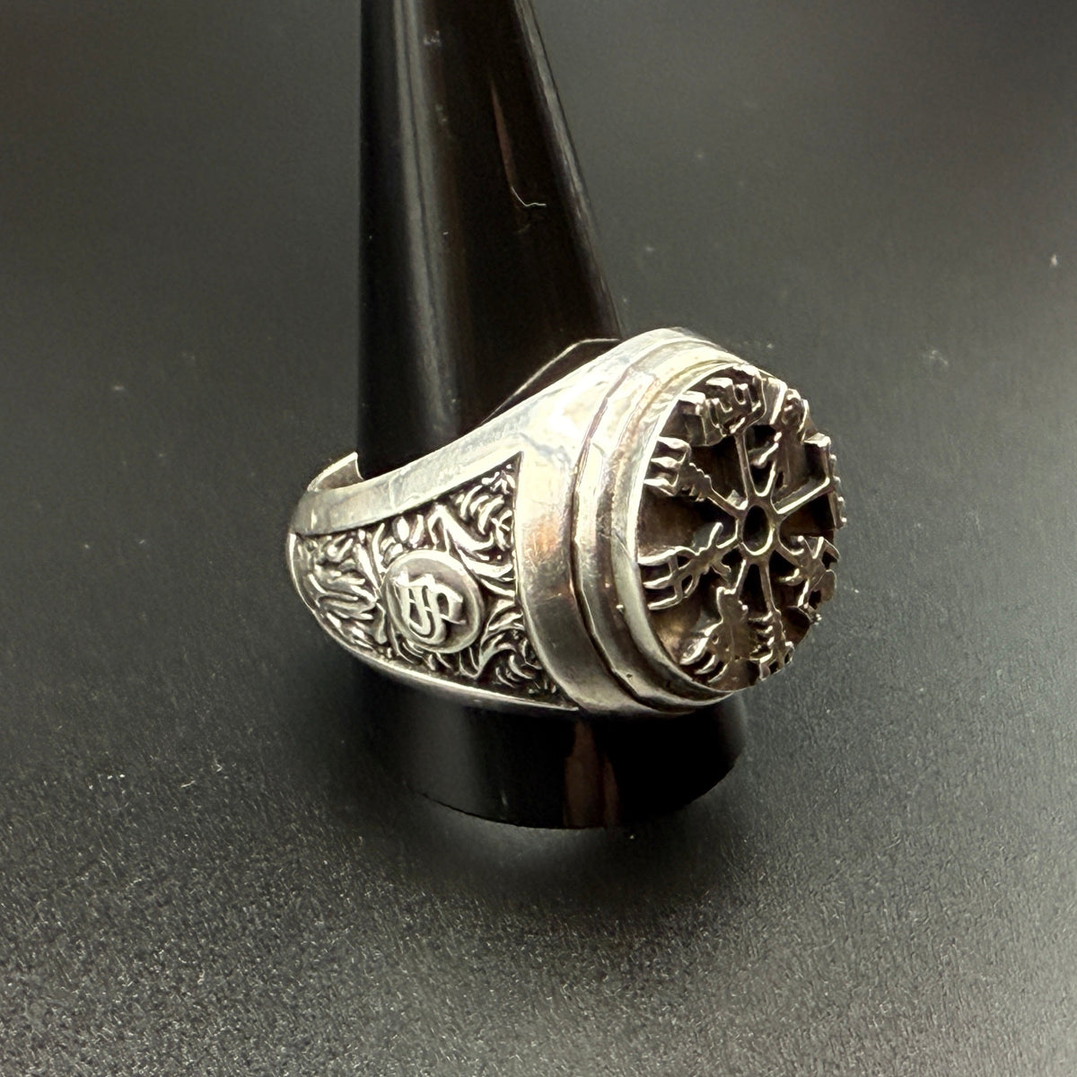 A sterling silver Viking-style ring with a raised compass motif and textured details