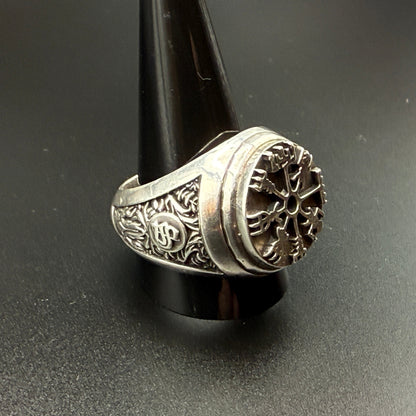A sterling silver Viking-style ring with a raised compass motif and textured details