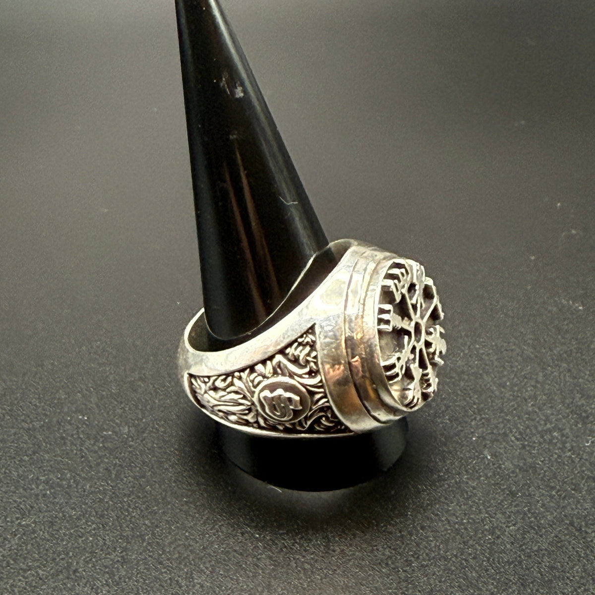 A sterling silver Viking-style ring with a raised compass motif and textured details and customized "S" monogram on side