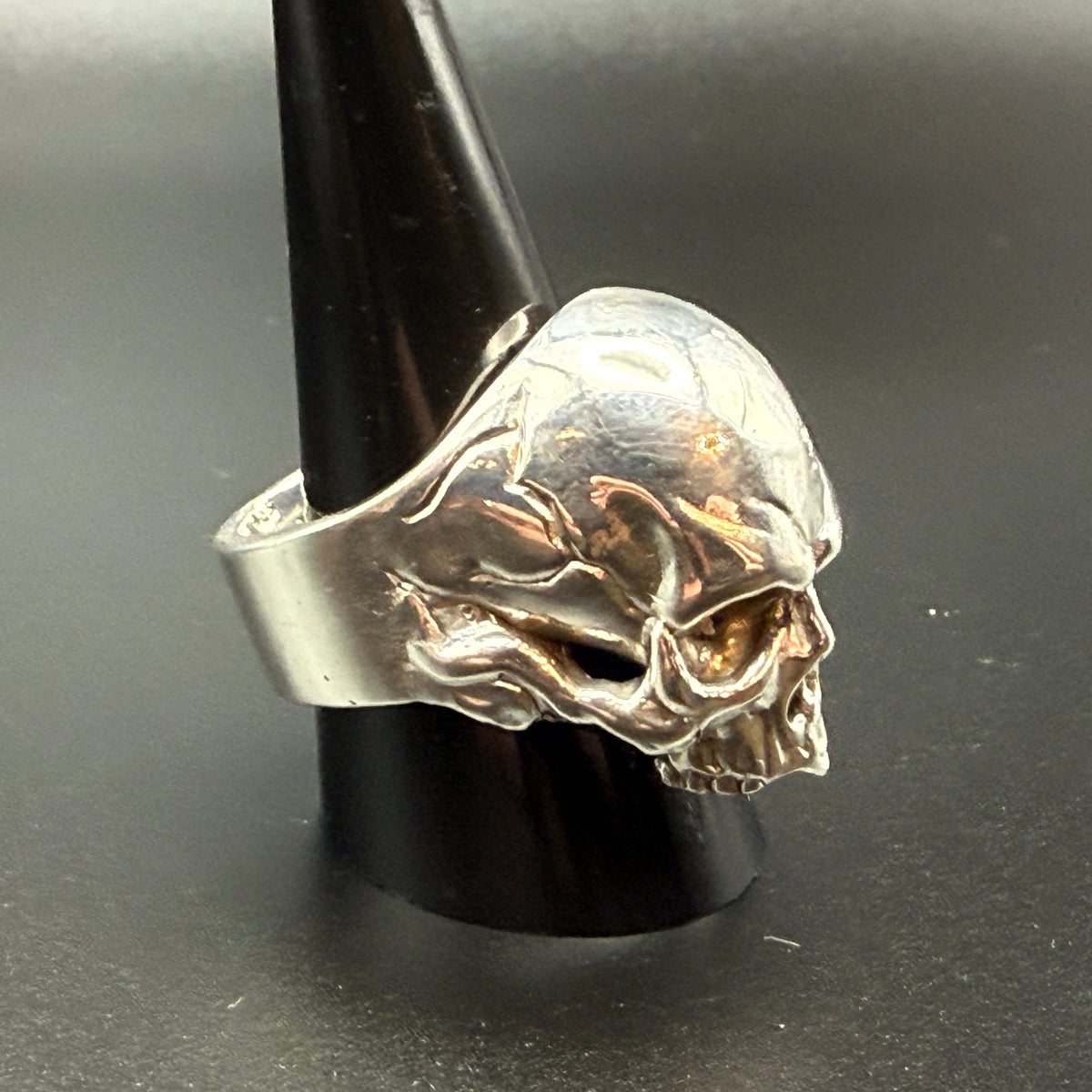 A silver skull ring  - side view