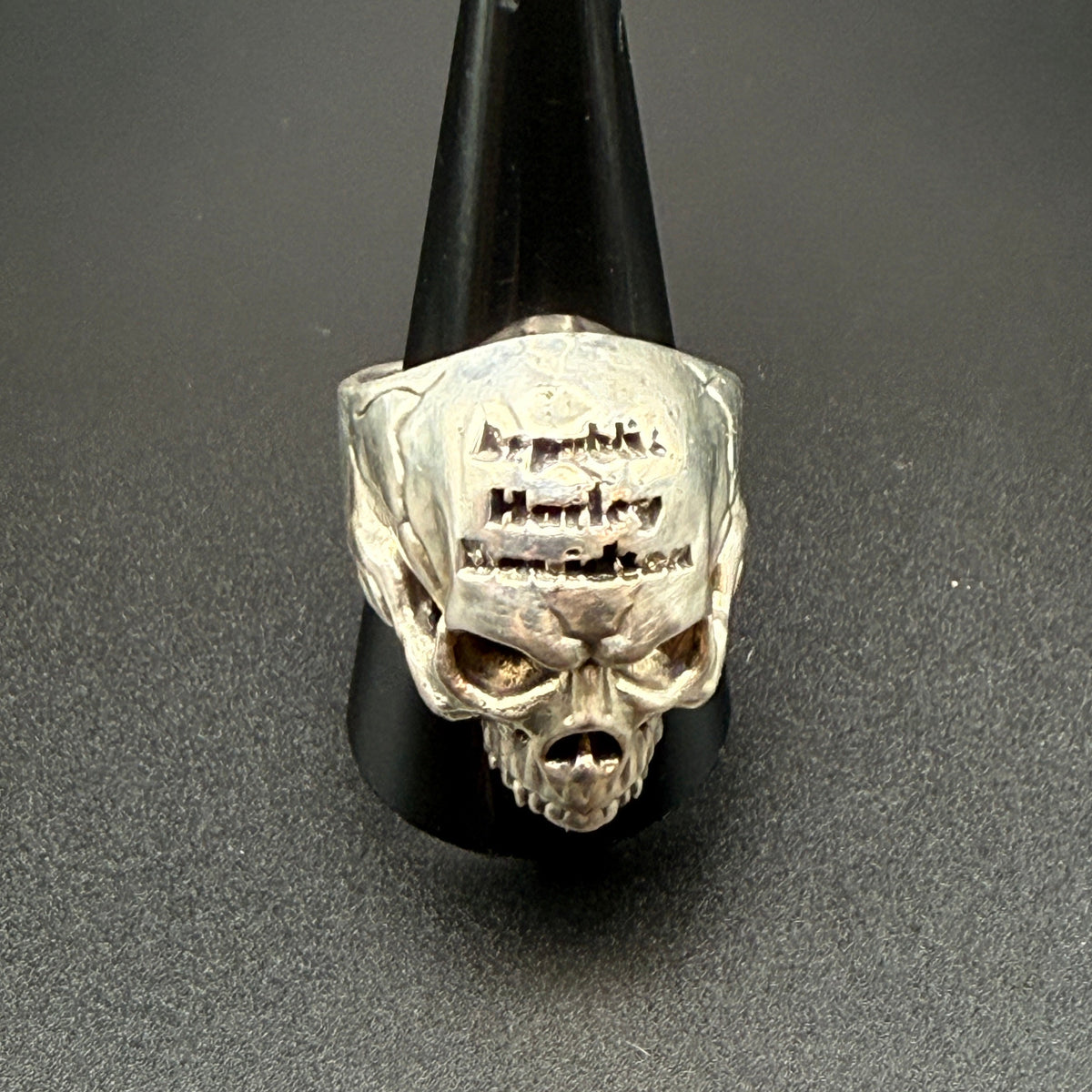 A silver skull ring with 'Republic Harley-Davidson' engraved on the forehead.