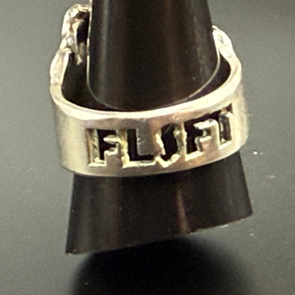 A silver skull ring with FLSFT' engraved on the band.