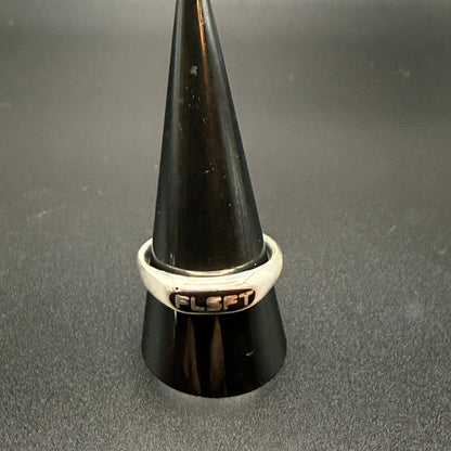 Narrow sterling silver signet rings with custom embedded lettering reading 'FLSFT'
