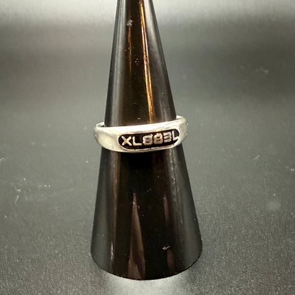 Narrow sterling silver signet rings with custom embedded lettering reading 'XL883L'