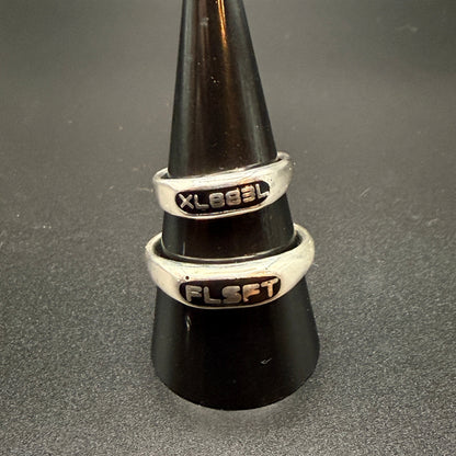 Two narrow sterling silver signet rings with custom embedded lettering reading "XL883L" and 'FLSFT'