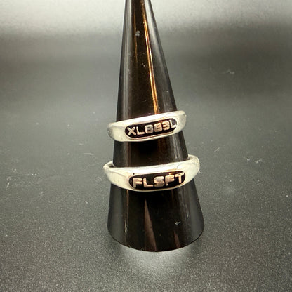Two narrow sterling silver signet rings with custom embedded lettering reading "XL883L" and 'FLSFT'