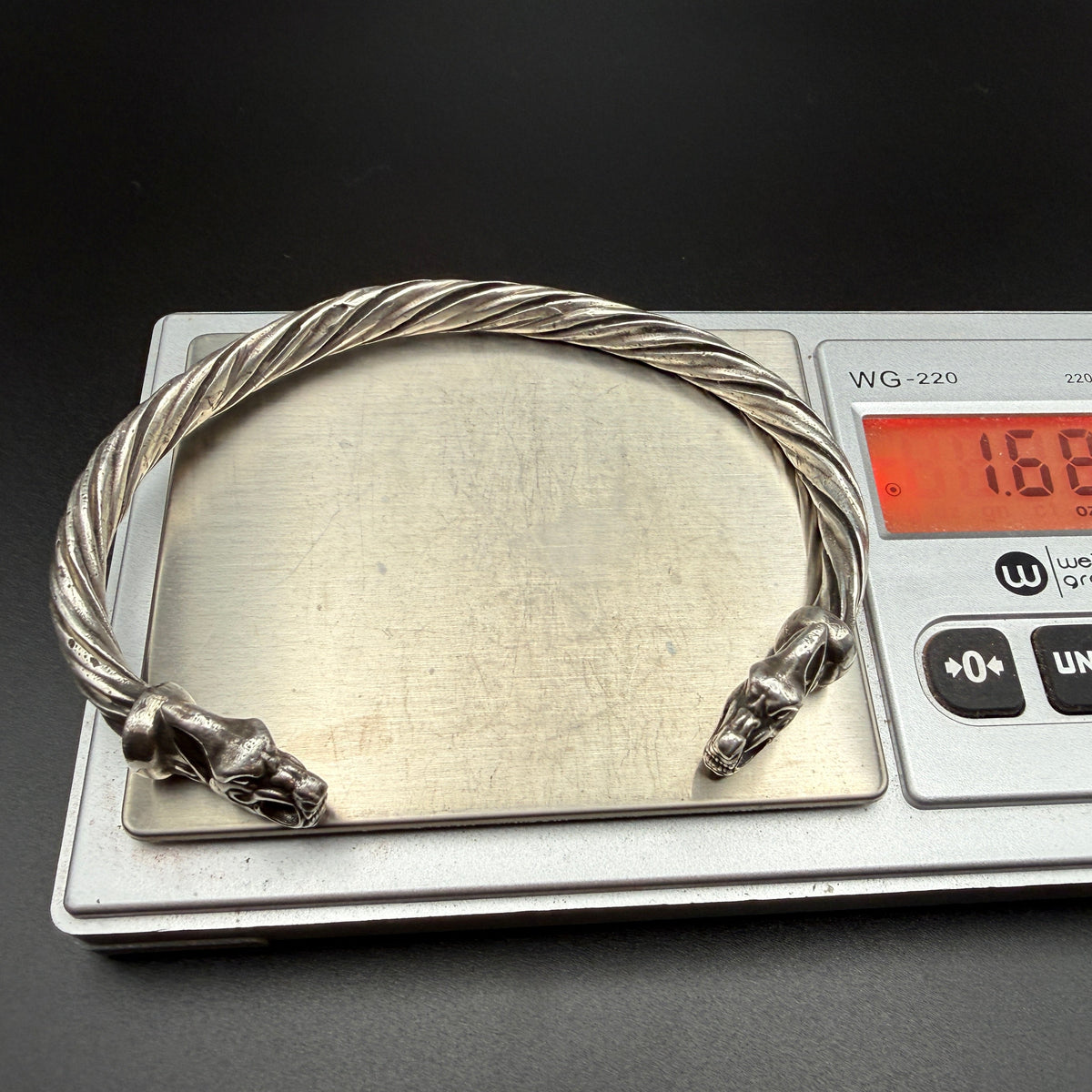 Solid sterling silver Viking bracelet with wolf heads on scale showing 1.68 troy ounces