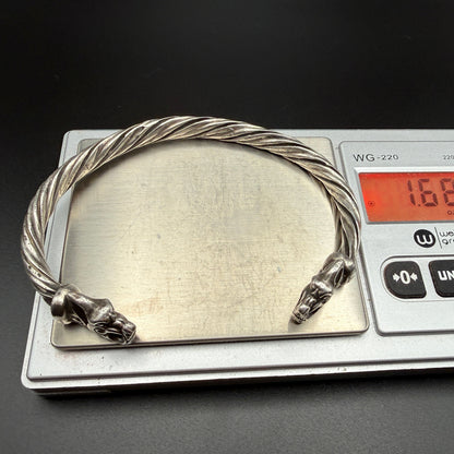 Solid sterling silver Viking bracelet with wolf heads on scale showing 1.68 troy ounces