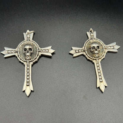 Two sterling silver gothic cross pendants with skull details.