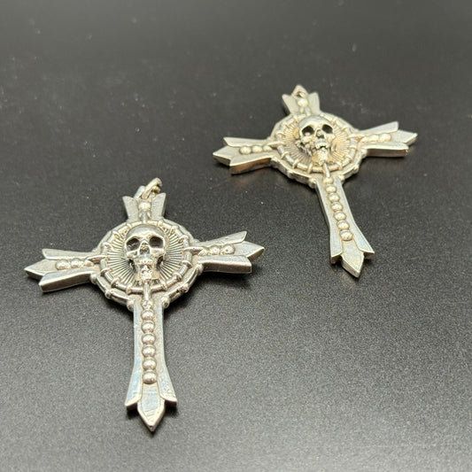 Two sterling silver gothic cross pendants with skull details.
