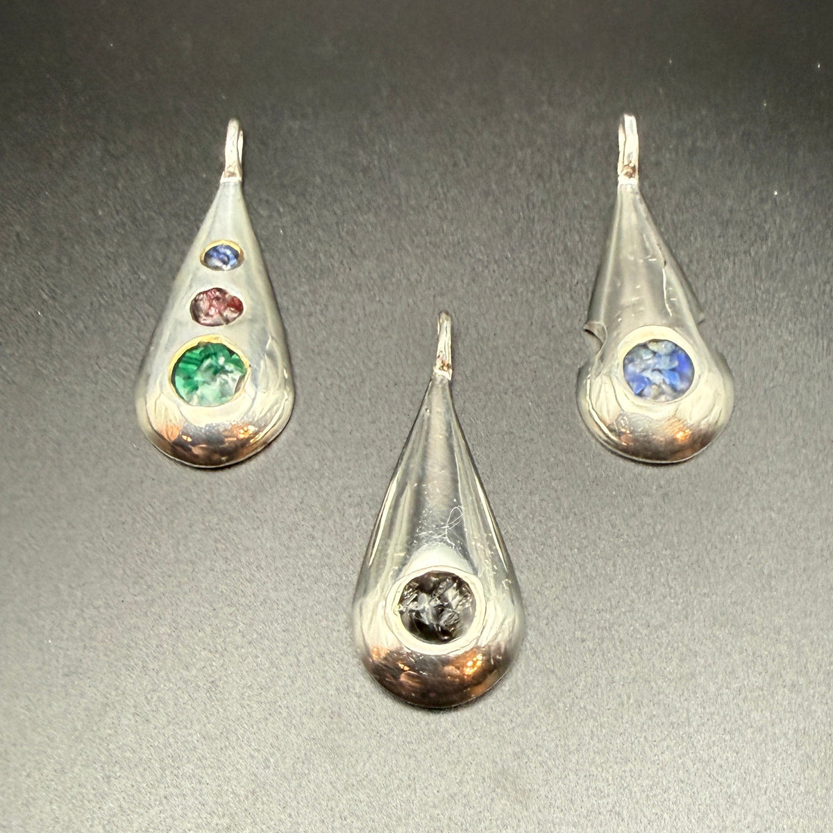 Three sterling silver teardrop pendants with   inlaid natural stones