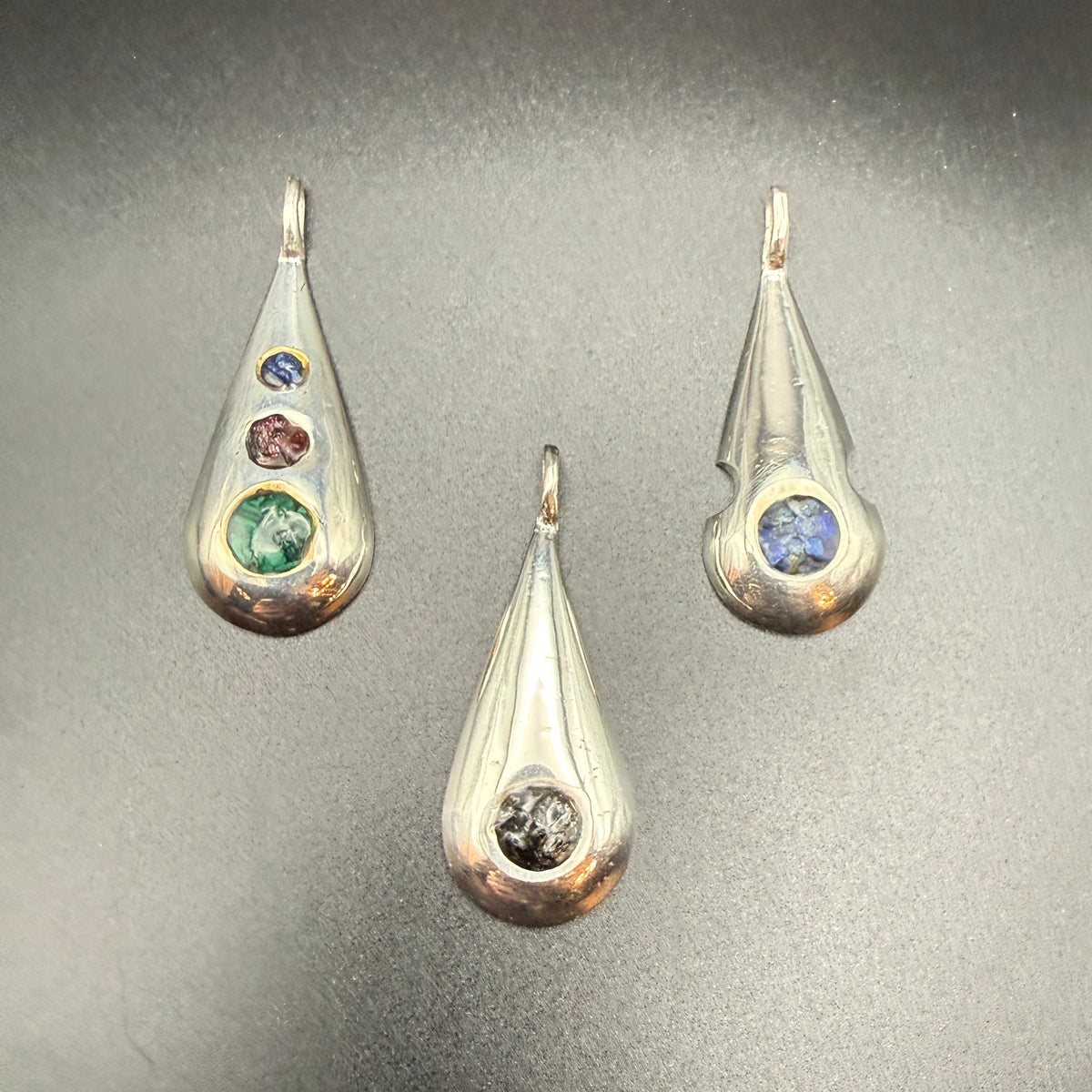 Three sterling silver teardrop pendants with   inlaid natural stones