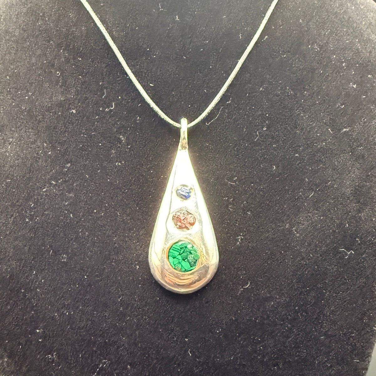 Handmade silver pendant with three natural stone chips and flat edge