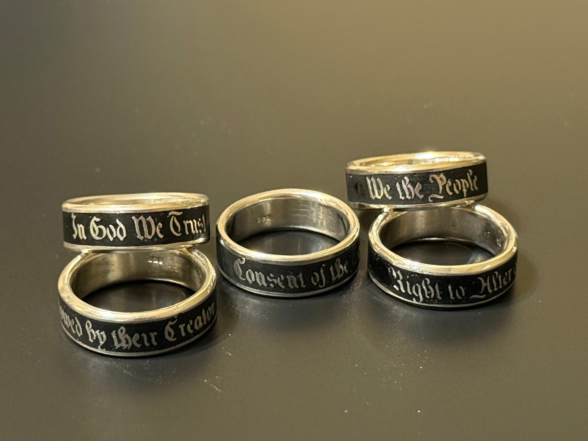 Collection of handmade embedded text silver bands with USA Patriot Theme