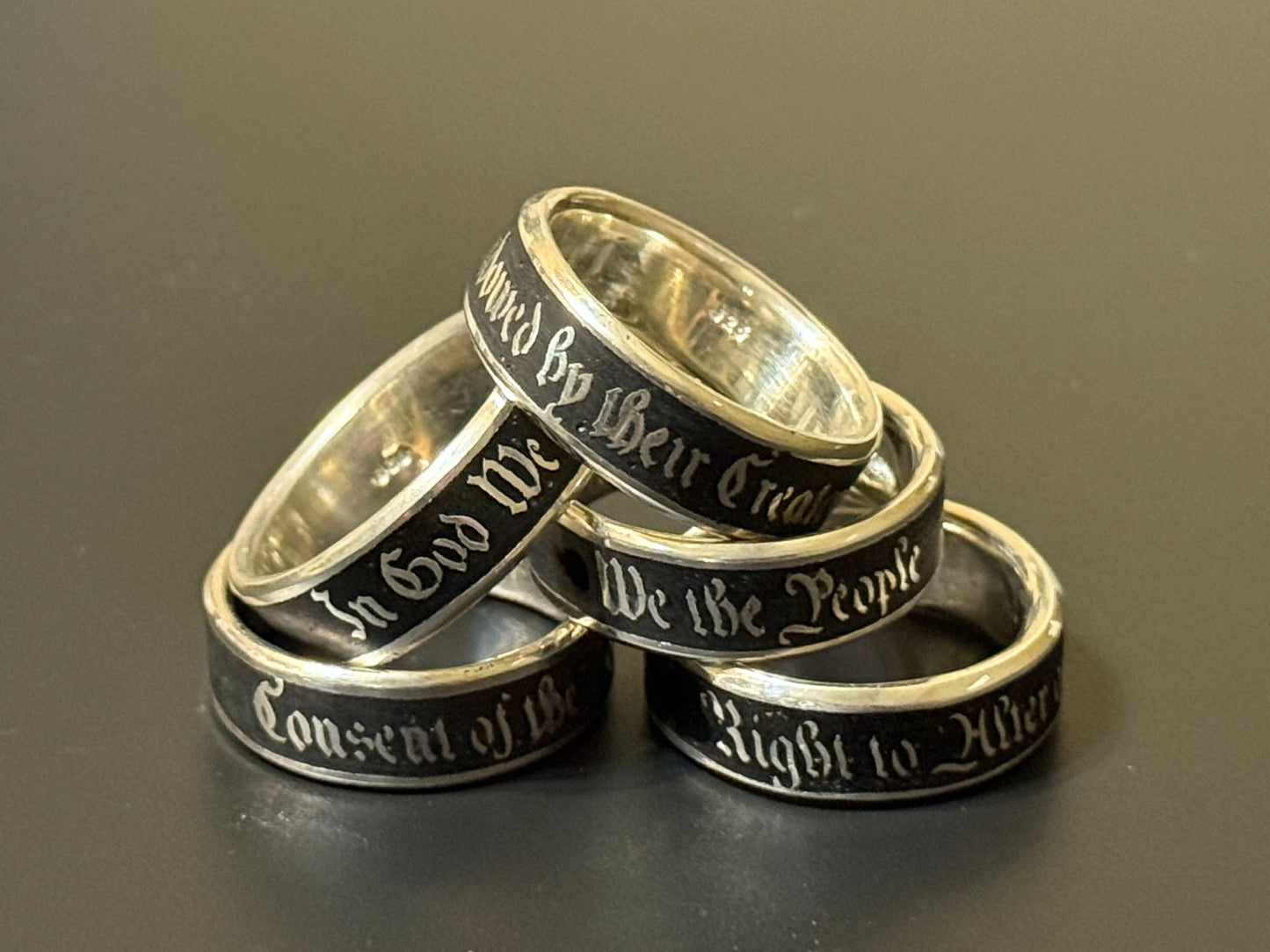 Collection of handmade embedded text silver bands with USA Patriot Theme