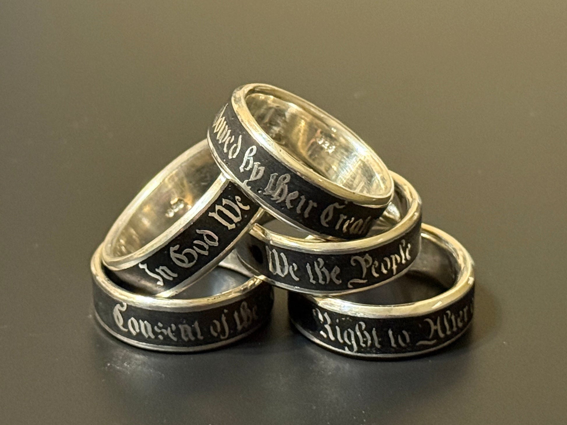 Collection of handmade embedded text silver bands with USA Patriot Theme