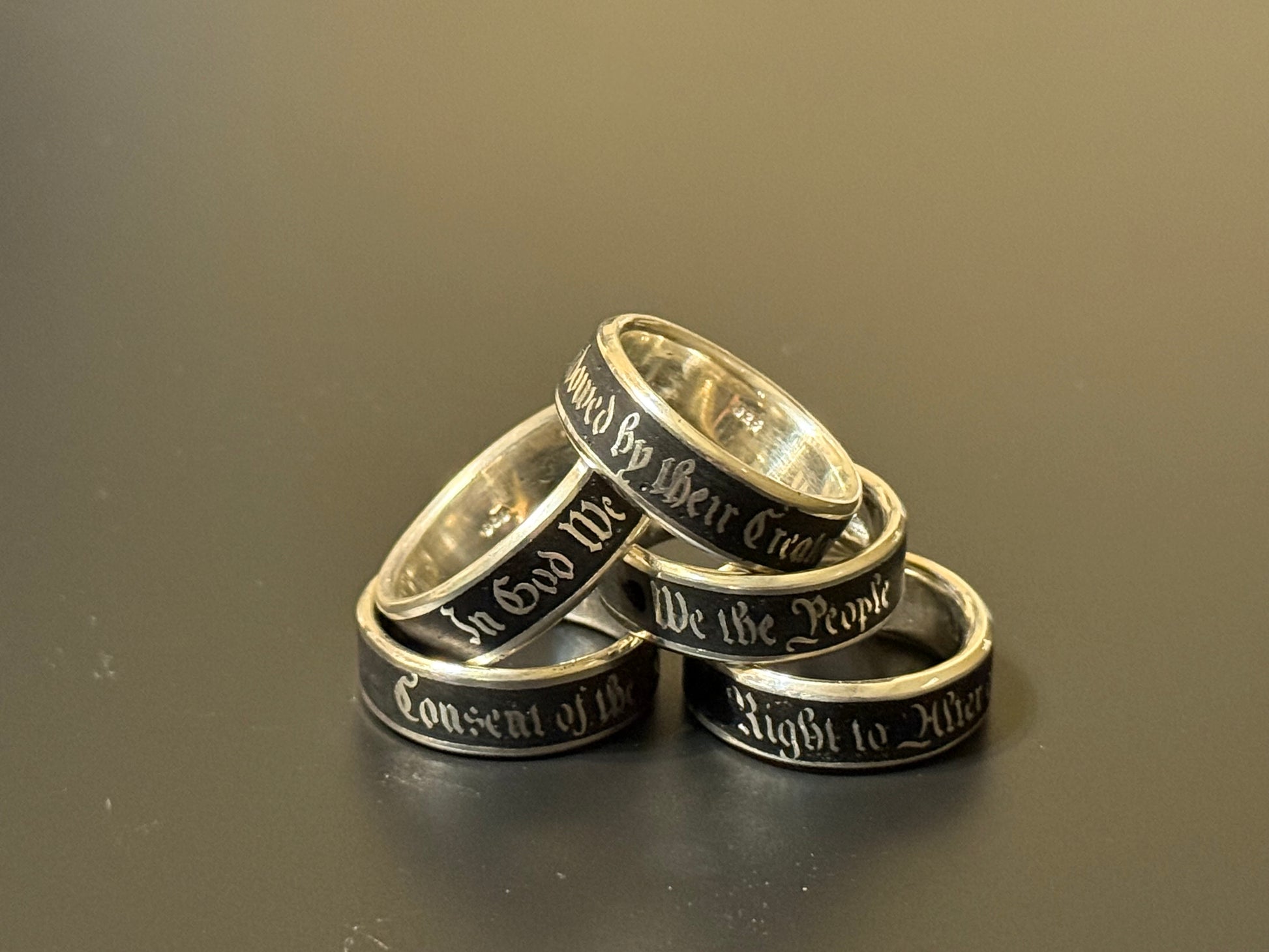 Collection of handmade embedded text silver bands with USA Patriot Theme