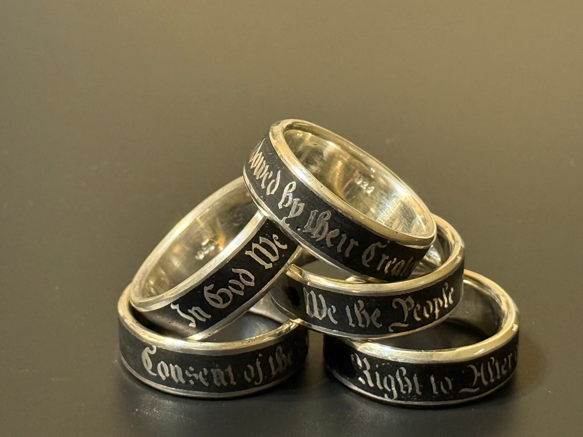 Collection of handmade embedded text silver bands with USA Patriot Theme