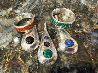 Collection of handmade rings and pendants with embedded natural stone chips