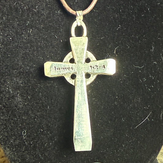 Silver cross pendant on a black background