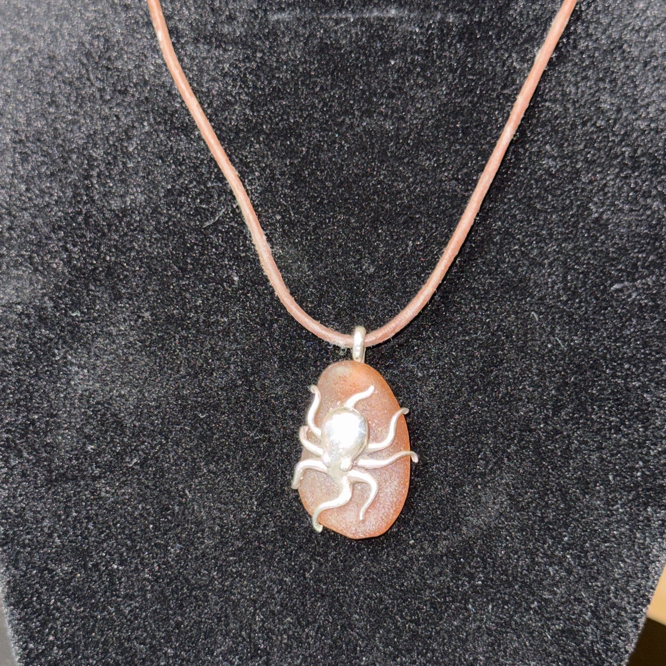 Small brown sea glass pendant with a silver octopus.