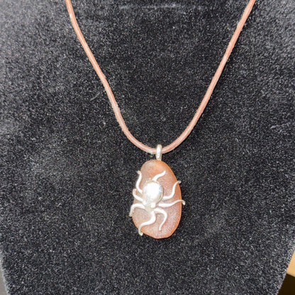 Small brown sea glass pendant with a silver octopus.