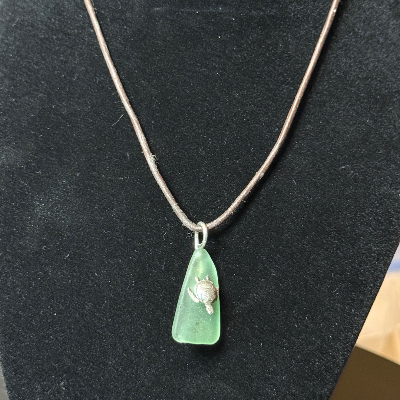 Small light green sea glass pendant with a silver sea turtle.