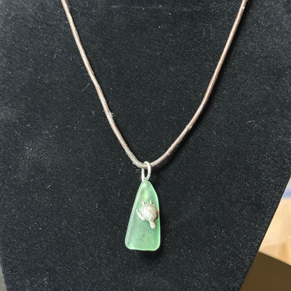 Small light green sea glass pendant with a silver sea turtle.