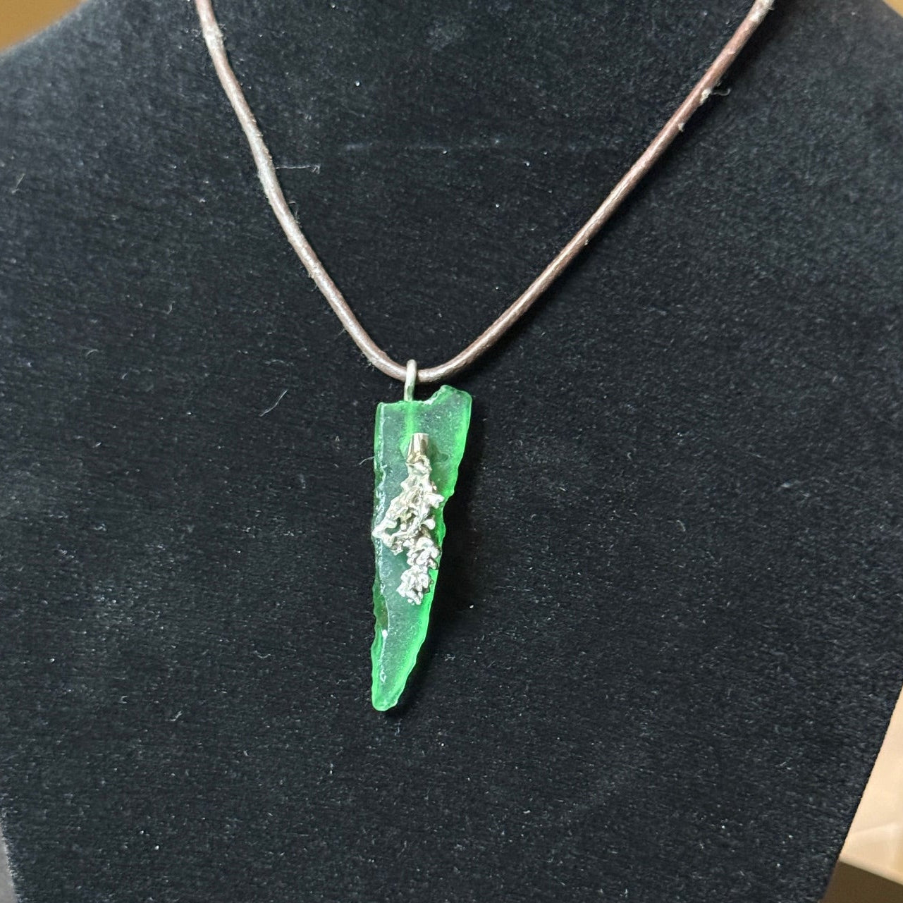 Small green sea glass pendant with a silver coral.