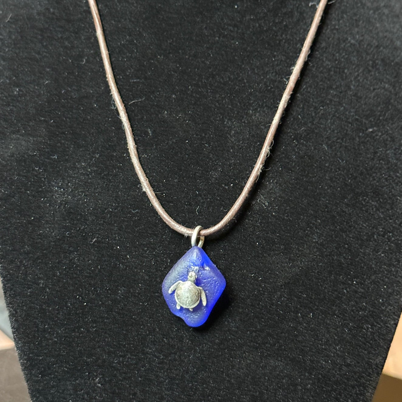 Small blue sea glass pendant with a silver sea turtle.