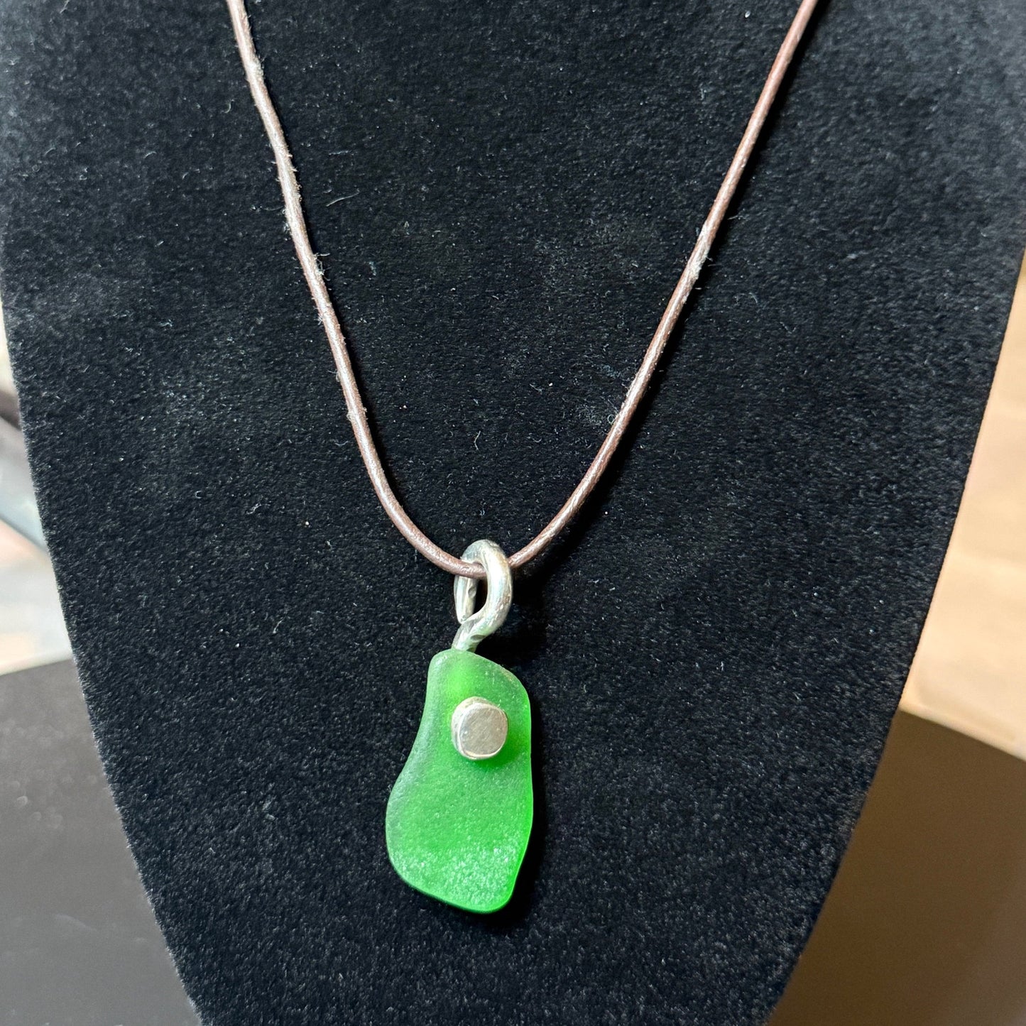 Medium green sea glass pendant with a silver button.