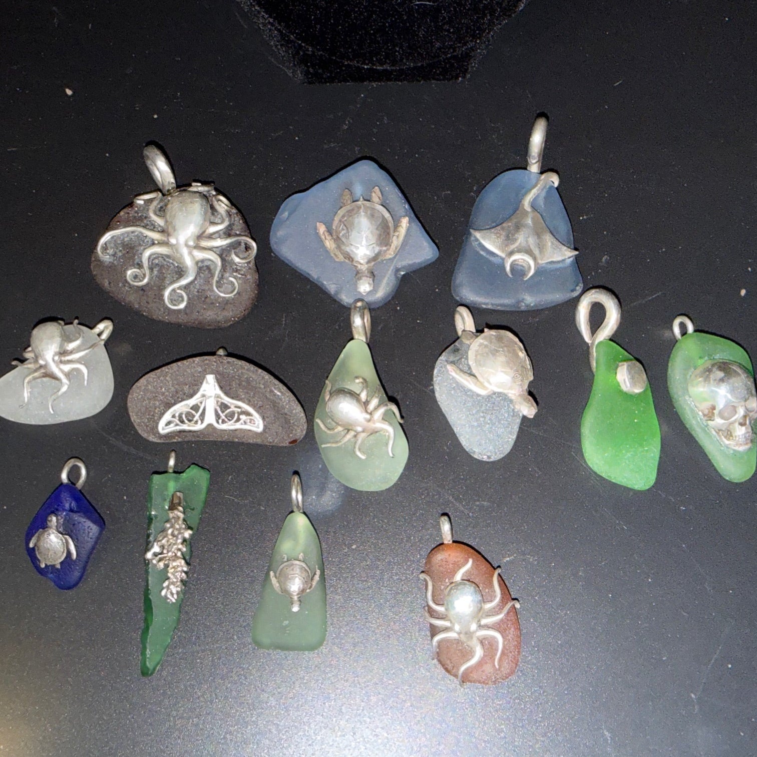 Collection of various sea glass pendants. Large on top row, medium in middle and small at bottom