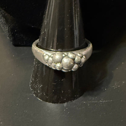 Stack of various size spheres clustered on narrow signet rings