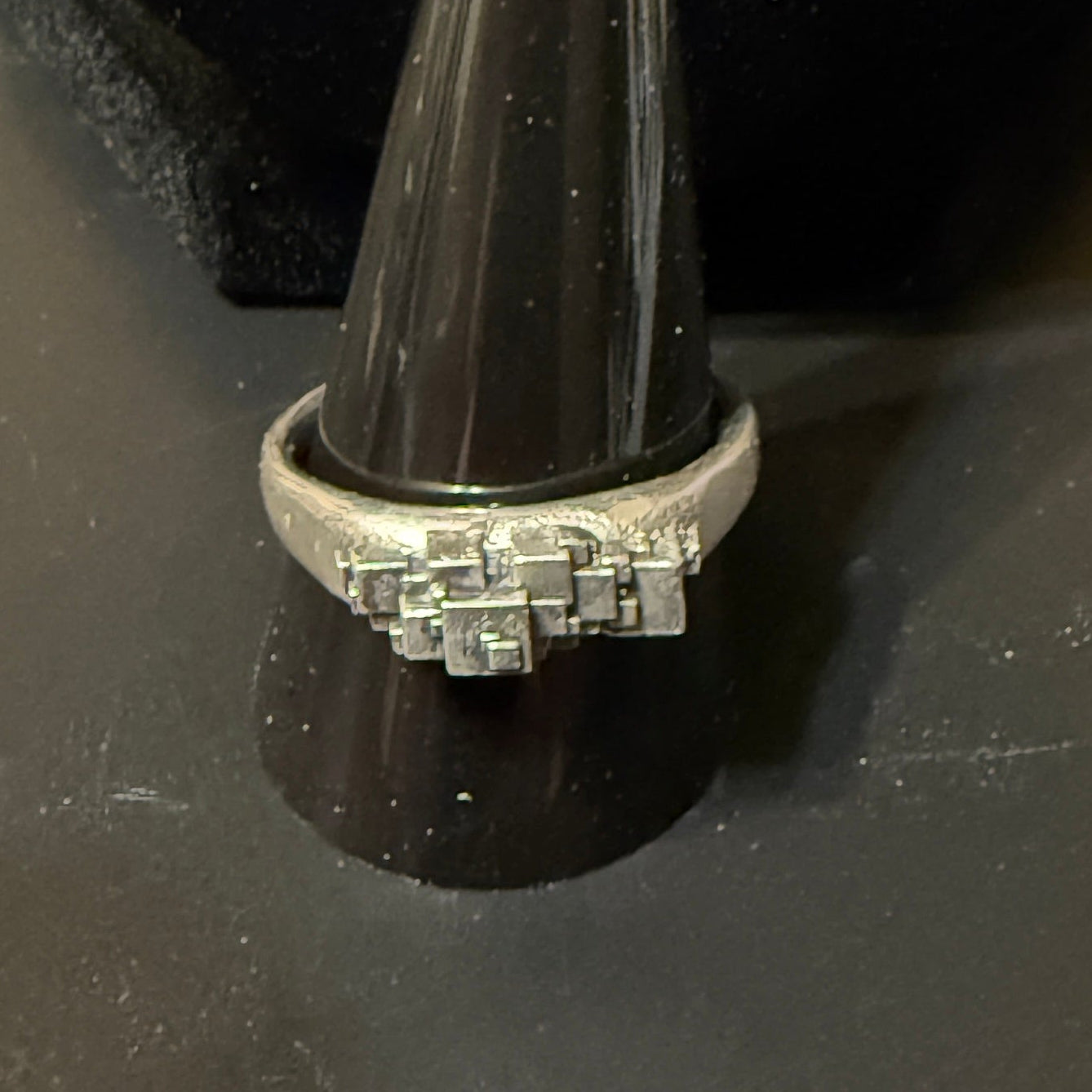 Stack of various size cubes clustered on narrow signet rings