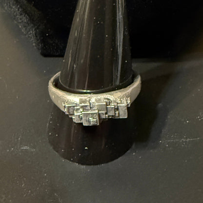 Stack of various size cubes clustered on narrow signet rings