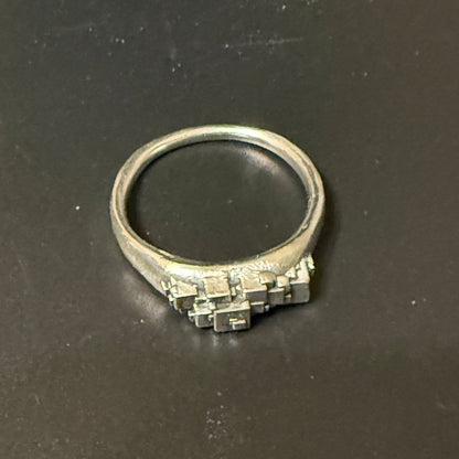 Stack of various size cubes clustered on narrow signet rings