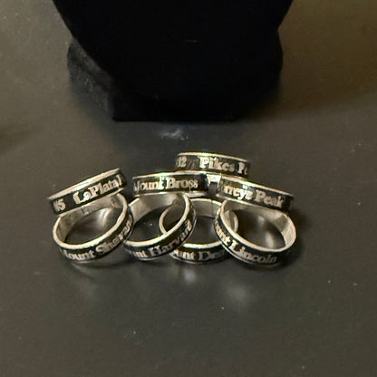 Set of silver rings with engraved text on a dark surface